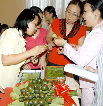 Teacher Phan Thi Thu Nguyet (C) instructed people how to arrange a “betel and areca tray” as part of wedding rites and worshipping ancestors. (Photo: Sggp)