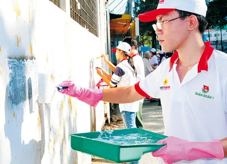 Thanh niên quận 1 xóa quảng cáo sai quy định, góp phần cho TPHCM văn minh sạch đẹp. Ảnh: VIỆT DŨNG