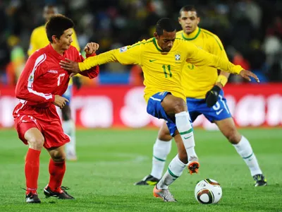 Robinho (số 11) đi bóng trước sự đeo bám của An Young-Hak (CHDCND Triều Tiên).