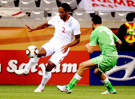 Hậu vệ Glen Johnson (trái) tranh bóng với hậu vệ Algeria Nadir Belhadj.