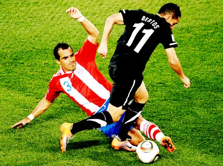 Hậu vệ Claudio Morel (3, Paraguay) truy cản pha tấn công của tiền vệ Leo Bertos (11, New Zealand).