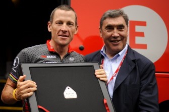 Lance Armstrong (L) poses with Tour de France five-times winner, Belgium's Eddy Merckx with a present in front of his team bus on July 5, 2010 in Brussels before the start of the 201 km and second stage of the 2010 Tour de France. AFP