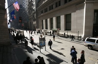 In this file photo taken March 9, 2010, people walk on Wall Street, in New York
