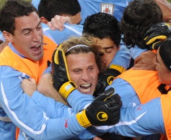 Diego Forlan (C) celebrates with teammates after scoring during the World Cup quarterfinal match between Uruguay and Ghana on July 2, 2010 at Soccer City stadium. AFP