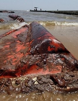 An oil coated containment boom is seen on the beach on July 9, in Waveland, Mississippi