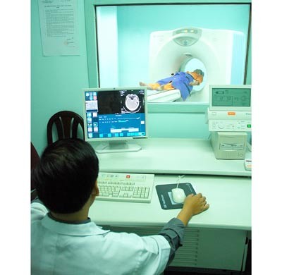 A patient undergo a CT scan which cost much. If hospital fees increase, it would become a burden to the poor (Photo: SGGP)