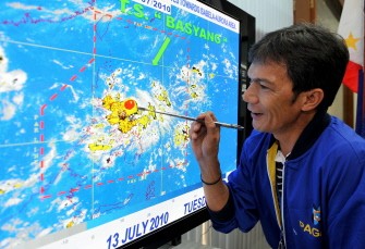 State weather forecaster Rene Paciente shows the movement of Typhoon Conson at the Philippine Atmospheric, Geophysical and Astronomical Services Administration in Quezon City suburban Manila on July 13, 2010. AFP