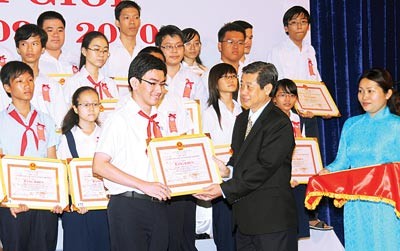Vice Chairman of the municipal People’s Committee Hua Ngoc Thuan gives certificates of merits to prominent students ( Photo: SGGP)