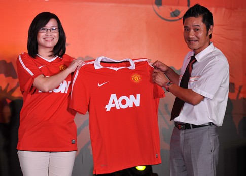 Two-time Golden Ball winner Nguyen Hong Son (R) receives a new Manchester United home shirt at an introduction in Hanoi on July 15.