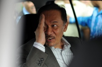 Anwar Ibrahim gestures in his car to supporters as he leaves court after a postponment in his trial due to the ill health of his lead council in Kuala Lumpur on July 19, 2010. AFP