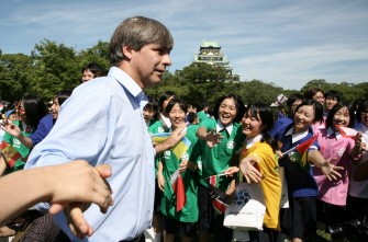 Harold Mayne-Nicholls (L) is greeted by Japanese football supporters as the inspection team visits Osaka on July 20, 2010. AFP