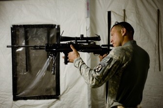 US Staff Sergeant Julio Jurado of 1st Platoon Bravo Troop of 1st Squadron, 71st Cavalry checks the aim of his rifle in his tent at a forward operating base in Dand district of Kandahar Province in Afghanistan on July 27, 2010. AFP