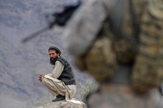 (FILES) In this photograph taken on December 19, 2009, an Afghan villager looks on as a US soldier from the Provincial Reconstruction team (PRT) Steel Warriors patrols in the mountains of Nuristan Province. AFP