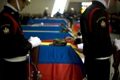 A guard of honour stands next to the coffins of nine navy soldiers during their funeral in Bogota, Colombia after they were killed by Marxist FARC rebels in the south of the country.