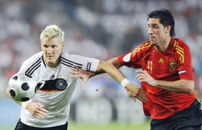 Tiền vệ Đức Bastian Schweinsteiger (trái) tranh bóng với hậu vệ Tây Ban Nha Joan Capdevilla.