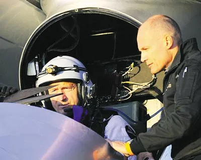 Phi công Andre Borschberg trong buồng lái trao đổi với Bertrand Piccard trước khi cất cánh. Ảnh: REUTERS