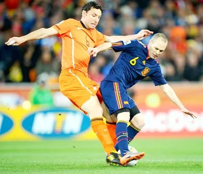 Iniesta (6, Tây Ban Nha) tranh bóng với Van Bommel (Hà Lan) trong trận chung kết.