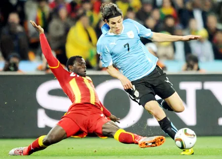 Tiền đạo Uruguay Edinson Cavani (phải) đi bóng qua cầu thủ Ghana ở tứ kết World Cup 2010.