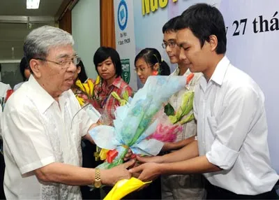 Giáo sư - Tiến sĩ khoa học Nguyễn Khánh Dư tặng hoa chúc mừng các SV nhận học bổng. Ảnh: Mai Hải