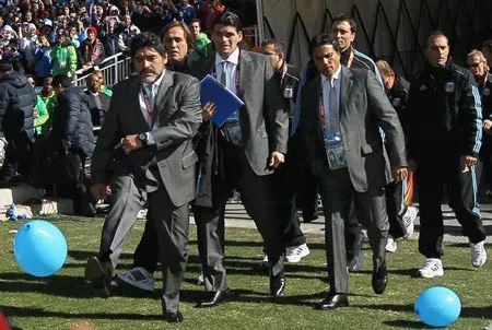 Maradona (trái) dẫn đầu đoàn các thành viên trong ban huấn luyện đội tuyển Argentina ra sân trong trận Argentina gặp Hàn Quốc tại World Cup 2010.