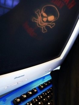 Skull and crossbones reflected in a computer screen