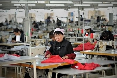 A Chinese worker looks on from her work station at a garment factory in Pinghu some 100 kms from Shanghai earlier this year