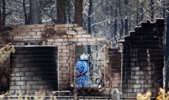A Russian woman stands near the remains of her burnt out home in Voronezh on August 2, 2010. AFP