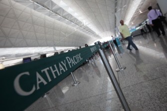 Travellers walk past a Cathay Pacific check-in barrier at Hong Kong international airport on August 4, 2010. AFP