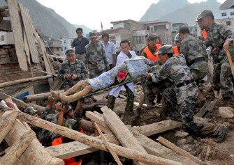 Rescuers carry a survivor who was found in debris after a deadly flood-triggered landslide hit Zhouqu, in northwest China's Gansu province on August 8, 2010. AFP