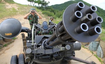 South Korean marines stand guard at an anti-aircraft gun position during a military exercise in Baengnyeong Island, near the disputed Yellow Sea border between the two Koreas, on August 8, 2010. AFP
