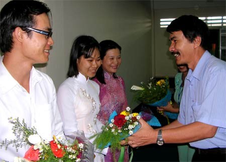 This undated file photo shows Can Tho University’s principal Nguyen Anh Tuan (R) give flowers to candidates sent abroad to study under the Mekong 1,000 project (Photo: SGGP)