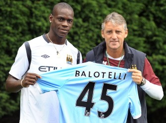 Mario Balotelli (L) poses for photographers with Manchester City manager Roberto Mancini at their Carrington training complex in Manchester on August 17, 2010. AFP