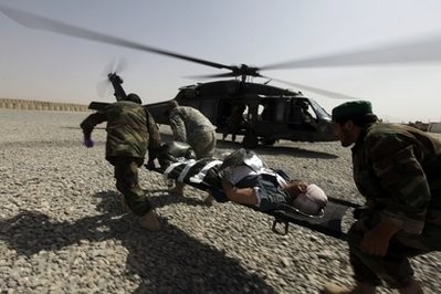 An Afghan police officer wounded in an ongoing firefight is loaded into a U.S. Army, 101st Airborne Division, Task Force Destiny medevac helicopter, at the Afghan and U.S. Forward Operating Base Howz-e-Madad, operated by the 101st, 2nd Battalion, 502nd Infantry Regiment, in Zhari district, Kandahar province, southern Afghanistan,