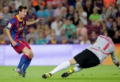 Lionel Messi (L) shoots past Sevilla's goalkeeper Andres Palop during a Super Cup football match at the Camp Nou Stadium in Barcelona. AFP