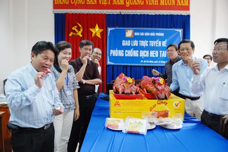 TBT báo SGGP Trần Thế Tuyển (bìa trái) cùng các đại biểu buổi giao lưu dùng thịt heo an toàn. Ảnh CAO THĂNG