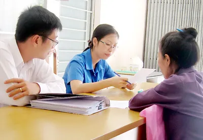 Cán bộ tiếp công dân của Thanh tra TPHCM đang hướng dẫn người dân làm đơn. Ảnh: L.T.HÂN