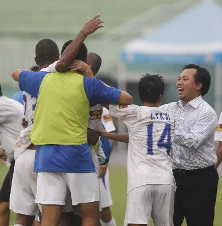 Ông Nguyễn Chí Kiên (bìa phải) chia vui cùng các cầu thủ TPHCM ở ngày trụ hạng. Ảnh: D.P