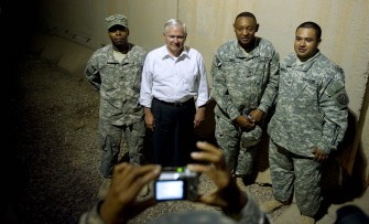 A soldier takes a picture of US Secretary of Defense Robert Gates (C) and some troops after he had dinner with troops at the Sports Oasis dining facility at Camp Victory in Baghdad, on September 1, 2010. AFP