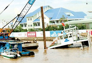 A rescue team work to fish cars out of the sunken ferry (R) on Sep. 23, 2010 (Photo: SGGP)