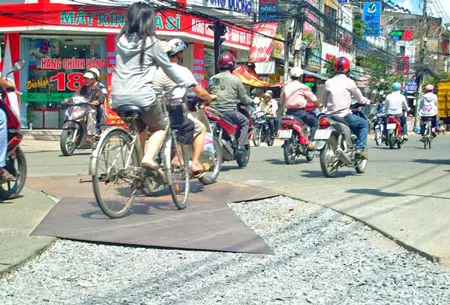 Nhiều tấm thép đặt trên phần mặt đường khiến người lưu thông dễ bị trượt ngã khi mưa xuống (ảnh chụp trước nhà 198 Cách Mạng Tháng Tám, P10 Q3 TPHCM).