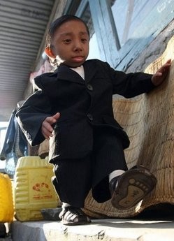 World's shortest teen Nepalese Khagendra Thapa Magar wears a suit as his home in Pokha. AFP