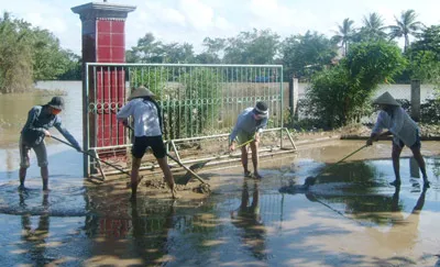 Người dân Quảng Trị thu gom lớp bùn non để lại sau khi nước lũ rút