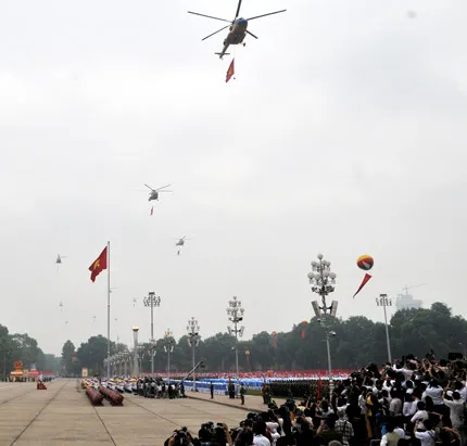 Các trực thăng mang cờ Đảng, cờ Tổ quốc và băng rôn chào mừng đại lễ.