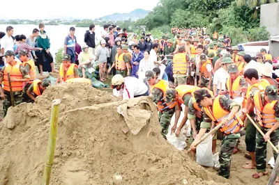 Lực lượng bộ đội, công an và người dân TP Phan Rang đắp đê sông Dinh ngăn lũ.