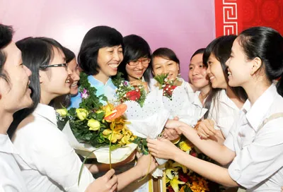 Các em học sinh ở Trung tâm Giáo dục thường xuyên quận Tân Phú tặng hoa chúc mừng cô Khúc Thị Quỳnh Hoa. Ảnh: MAI HẢI