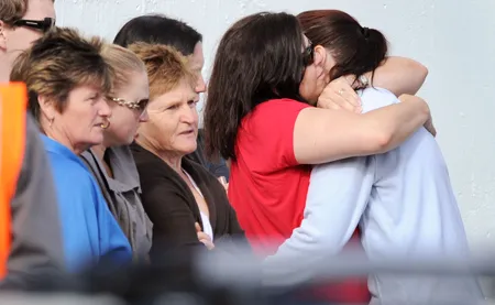 Người thân của 29 thợ mỏ mất tích động viên nhau. Ảnh: AFP