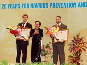 Vice President Nguyen Thi Doan hands medals to Earmon Murphy and Mitchell Wolfe