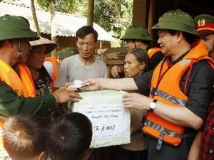 Prime Minister Nguyen Tan Dung (R) hands emergency relief to flood victims in the central province of Ha Tinh on October 20, 2010.(Photo:VNA)