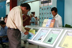 Clients collect circulars advertising houses and apartments for sales at a HCMC-based real estate firm (Photo: Minh Tri)
