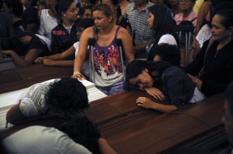 Relatives mourn over the coffins of their beloved ones killed after a landslide at La Gabriela neighborhood, during their funeral service, on December 7, 2010, in Bello. AFP